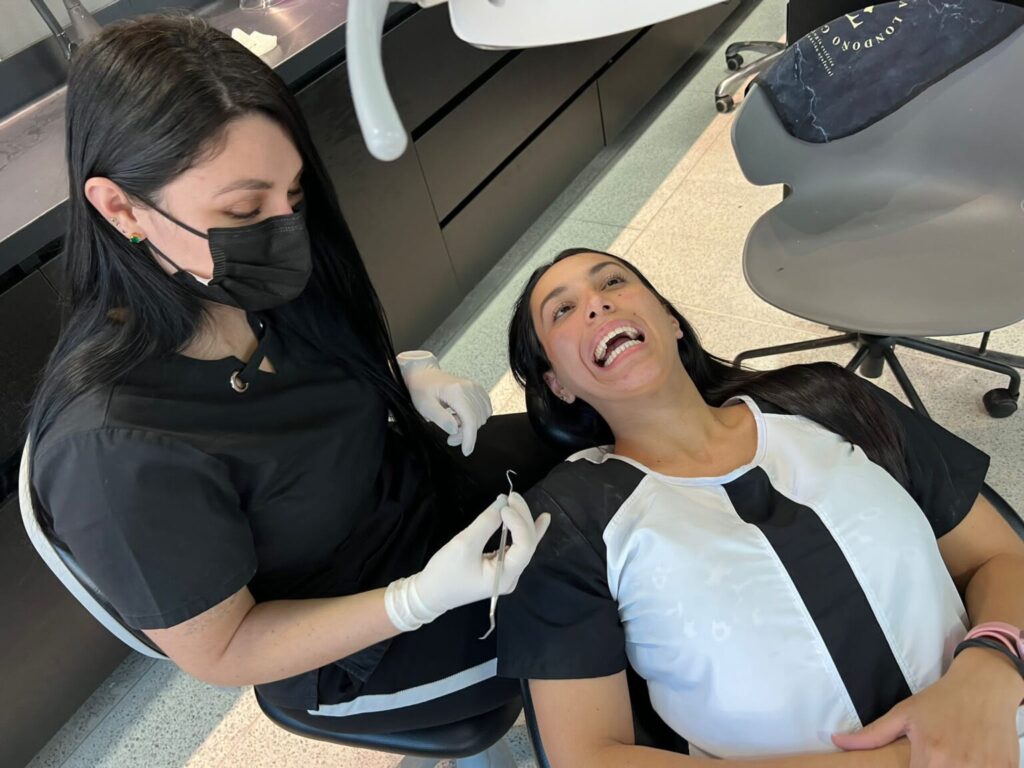 A woman receives dental care while wearing a mask.