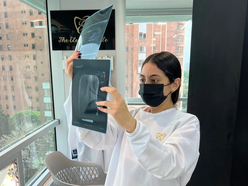 Person wearing a mask taking a selfie in a modern indoor setting.